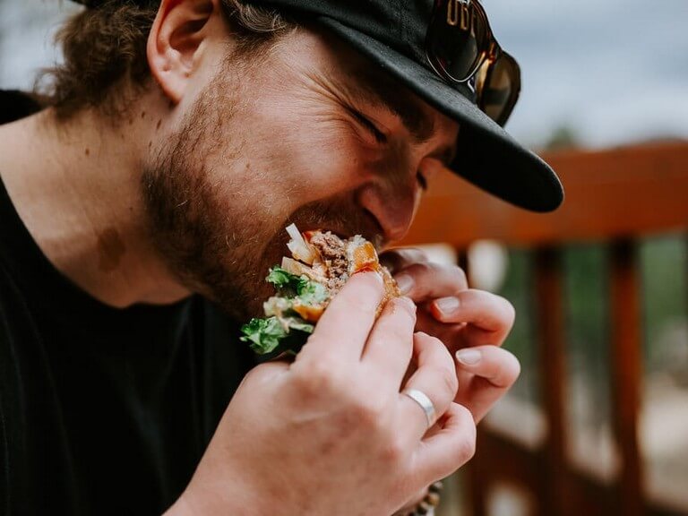 Man enjoying his burger on top of the Mountain Top Grille